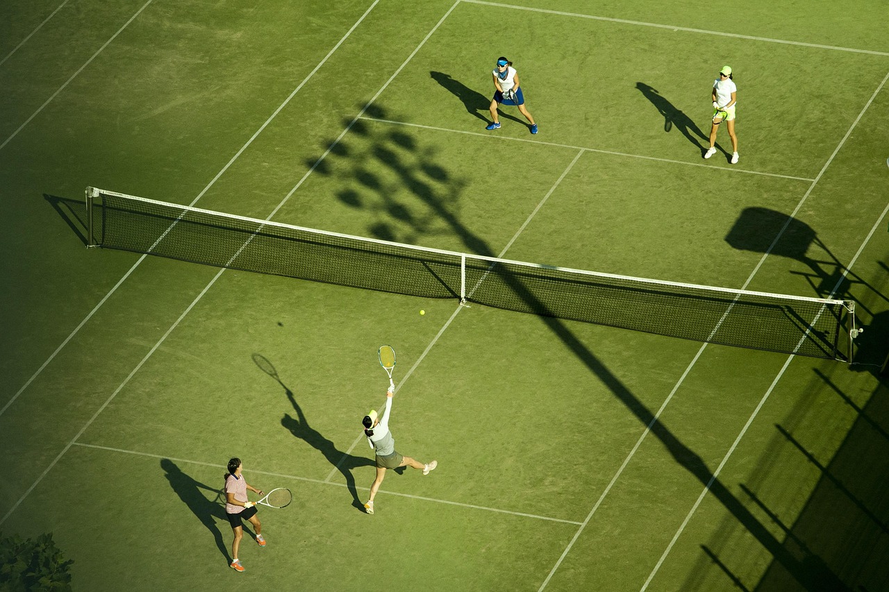 quatres joueurs terrain de tennis gazon